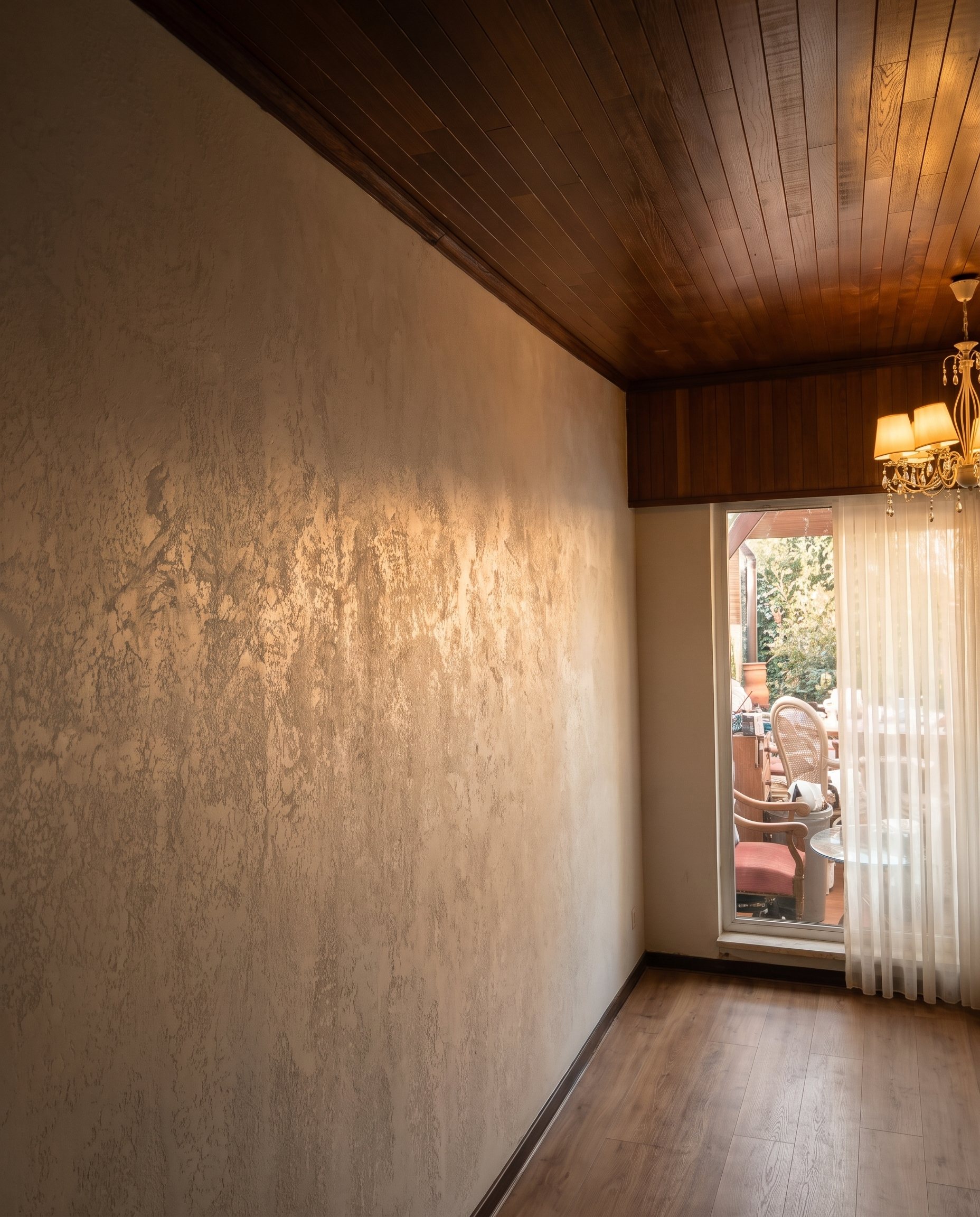 Finished white textured wall under warm chandelier light
